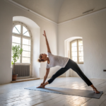 Persona pratica yoga in posizione di equilibrio su tappetino in ambiente luminoso a Pavia
